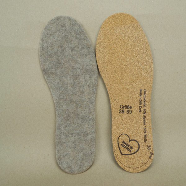 Zwei Schuheinlagen aus Alpakafilz. Auf der ersten Schuheinlage ist die Oberseite aus Alpakafilz zu sehen. Auf der zweiten Schuheinlage sieht man die Unterseite aus Kork.